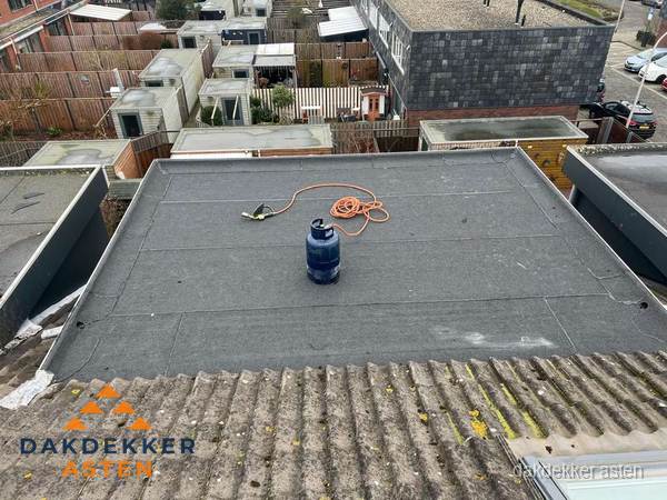 Plat dak met nieuwe bitumen dakbedekking en brandgereedschap in Asten