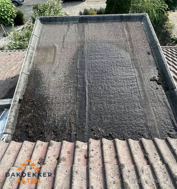 Verouderd plat dak met bitumen en slijtage voor lekkage inspectie in Asten Verouderd plat dak met bitumen en slijtage voor lekkage inspectie in Asten