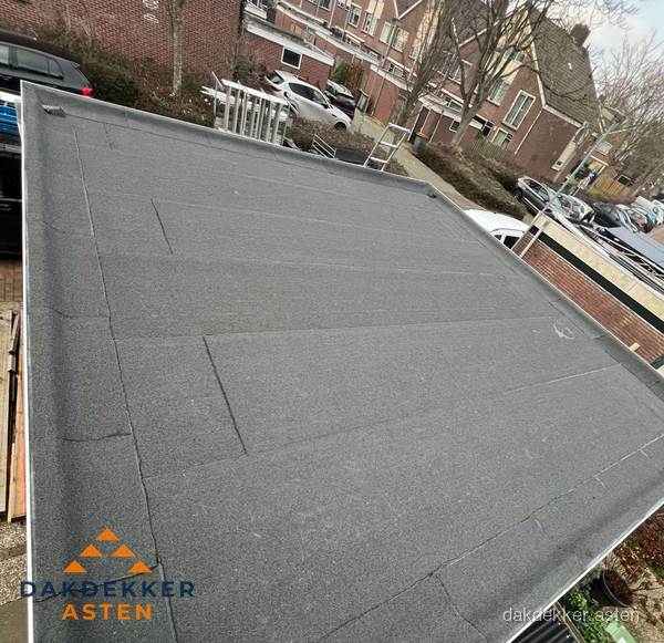 Nieuwe bitumen dakbedekking op plat dak van garage in Asten