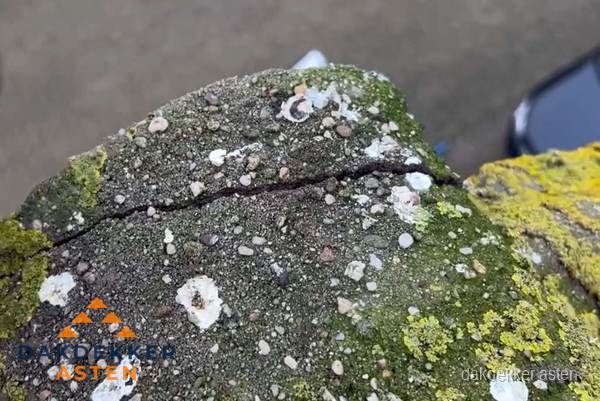 Beschadigde en verweerde nokvorst met scheuren en mos in Asten Beschadigde en verweerde nokvorst met scheuren en mos in Asten