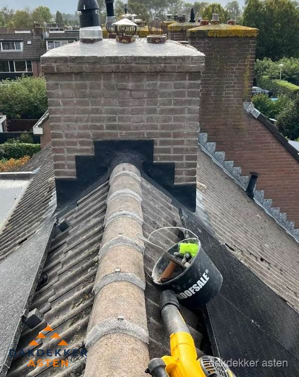 Schoorsteen met loodaansluiting en nokvorst op pannendak in Asten Schoorsteen met loodaansluiting en nokvorst op pannendak in Asten