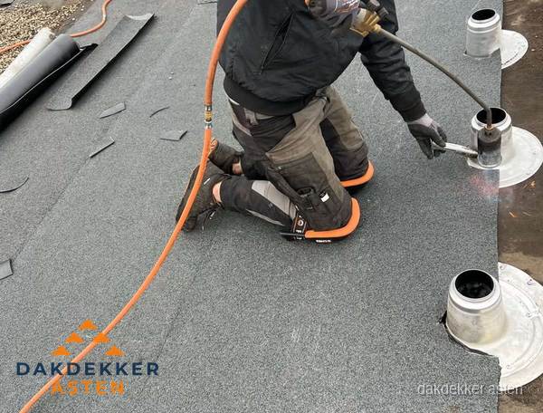 Dakdekker repareert bitumen dakleer bij dakdoorvoer in Asten Dakdekker repareert bitumen dakleer bij dakdoorvoer in Asten