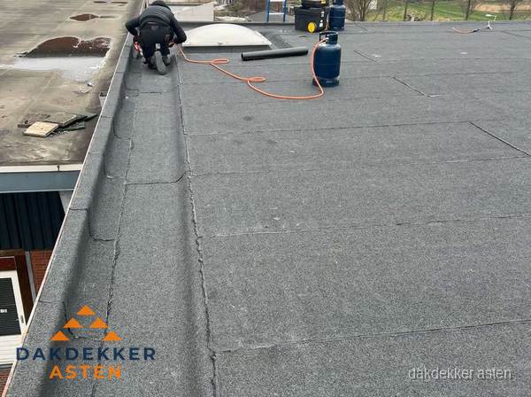 Dakdekker repareert bitumen dakbedekking op groot plat dak in Asten Dakdekker repareert bitumen dakbedekking op groot plat dak in Asten