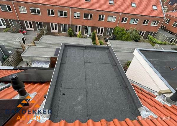 Plat dak met bitumen bedekking naast dakkapel in Asten